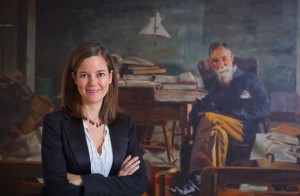 Alix Ohlin, associate professor of English, stands in front of a portrait painting of the late Lafayette English professors Francis A. March