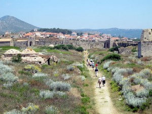 Travelers walk along a path the village of Methoni, Greece.