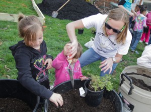 Sam Griffith ’13 helps children from the Easton Area Community Center plant flowers.