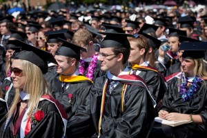 Students in caps and gowns take in the Commencement ceremonies.