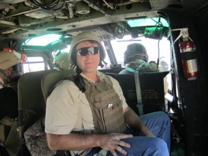 Keith Hanigan '85 sits in a Huey helicopter, the principal transportation in Iraq.