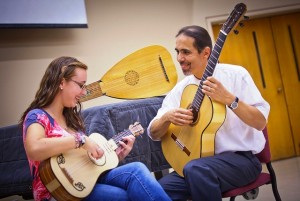 With guitar in hand, Jorge Torres gives guitar instruction to Shannon Moran '14.