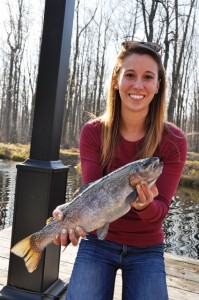 Brooke Kohler '13 holds a fish at the Dues' fish farm