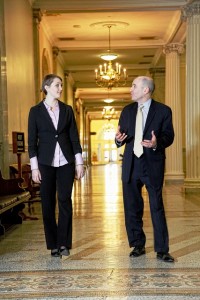 Jenna Gowell ’16 and Paul Brodeur ’86 talk in a hallway at the Massachusetts State House