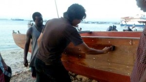 Yen Joe Tan ’14 helps with the staining of a dhow boat while studying abroad in Kenya.