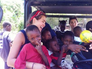 Madeleine O’Neill ’13 takes a break from her work in Haiti to play with village children.