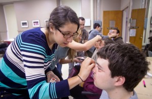 Students practice make-up aging techniques on each other.