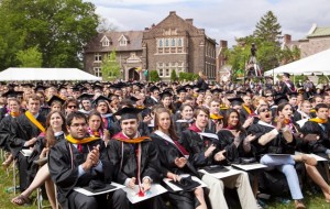 Students cheer as their classmates receive their degrees.
