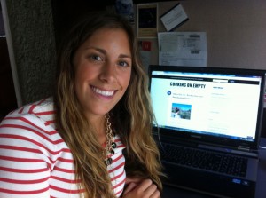 Megan Matusky '13 sits next to a computer displaying her cooking blog