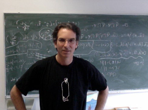 Silas Beane '88 standing in front of a blackboard filled with equations