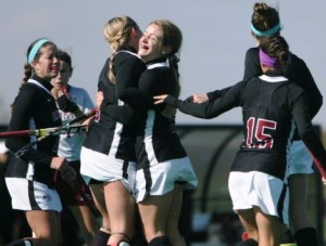 Members of the field hockey team celebrate after scoring a goal