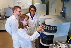 Chris Kelly ’13, Hollis Miller ’14, and Professor Kira Lawrence work in the lab.