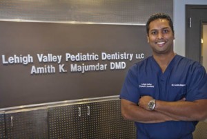 Dr. Amith Majumdar '95 stands in front of the sign bearing his name and "Lehigh Valley Pediatric Dentistry"