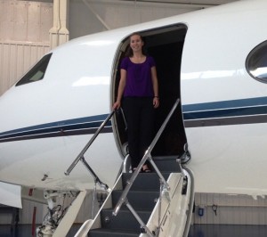 Bridget Rauch ’15 stands by a corporate aircraft powered with a Rolls-Royce engine 