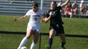 Caroline Craver '15 kicks the soccer ball while shielding it from a defender.