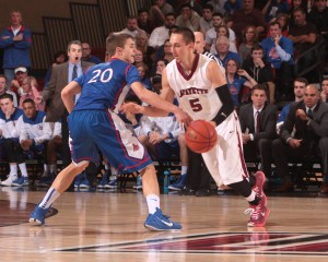 Joey Ptasinski dribbles the ball while an American University player defends.
