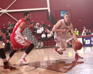 Nick Lindner dribbles the basketball while defended by a Boston University player