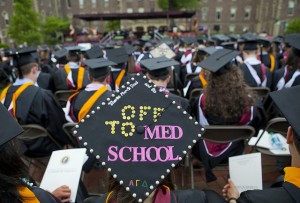 A rear view of graduating seniors during the 2014 Commencement includes a cap that has "Off  To Med School" on it