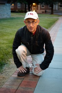 Robert Singer '65 poses with his Fleck Society brick on the Quad.