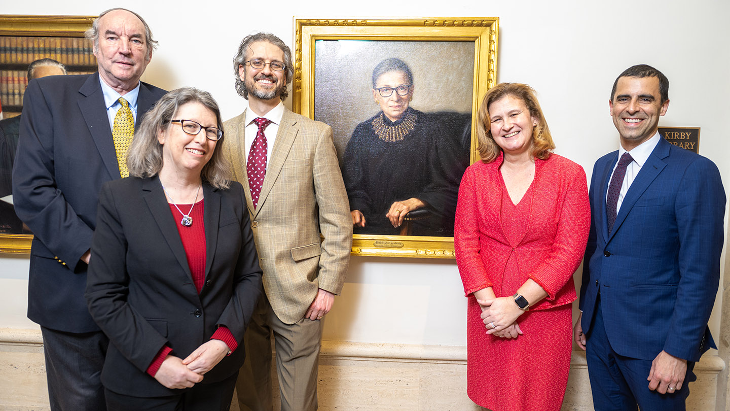 President Nicole Hurd and others smile by the 32-by-26-inch, oil-on-canvas painting of Ruth Bader Ginsburg.