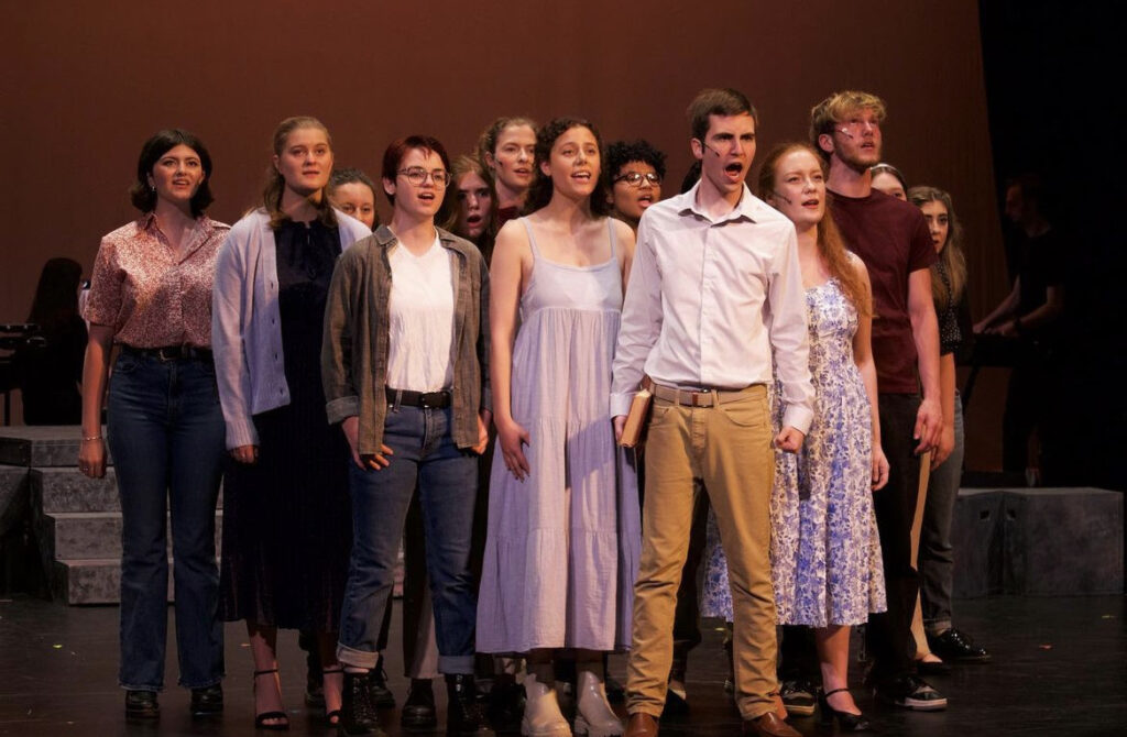 The cast of Footloose sings a song on stage during the Marquis Players' 2023 production.