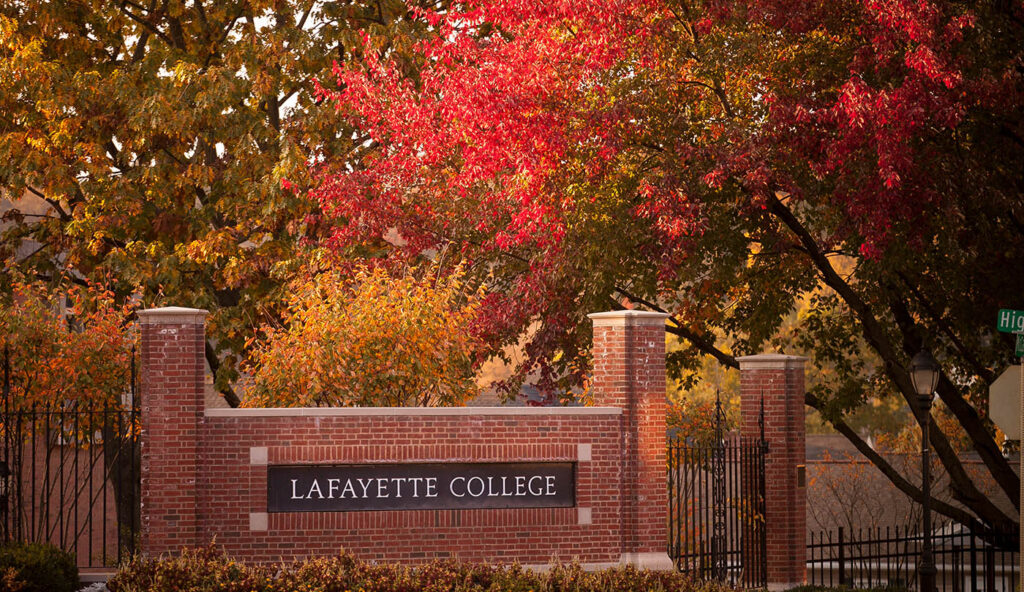 Sign reads "Lafayette College" near entrance to campus, surrounded by trees with red, yellow, and green leaves.
