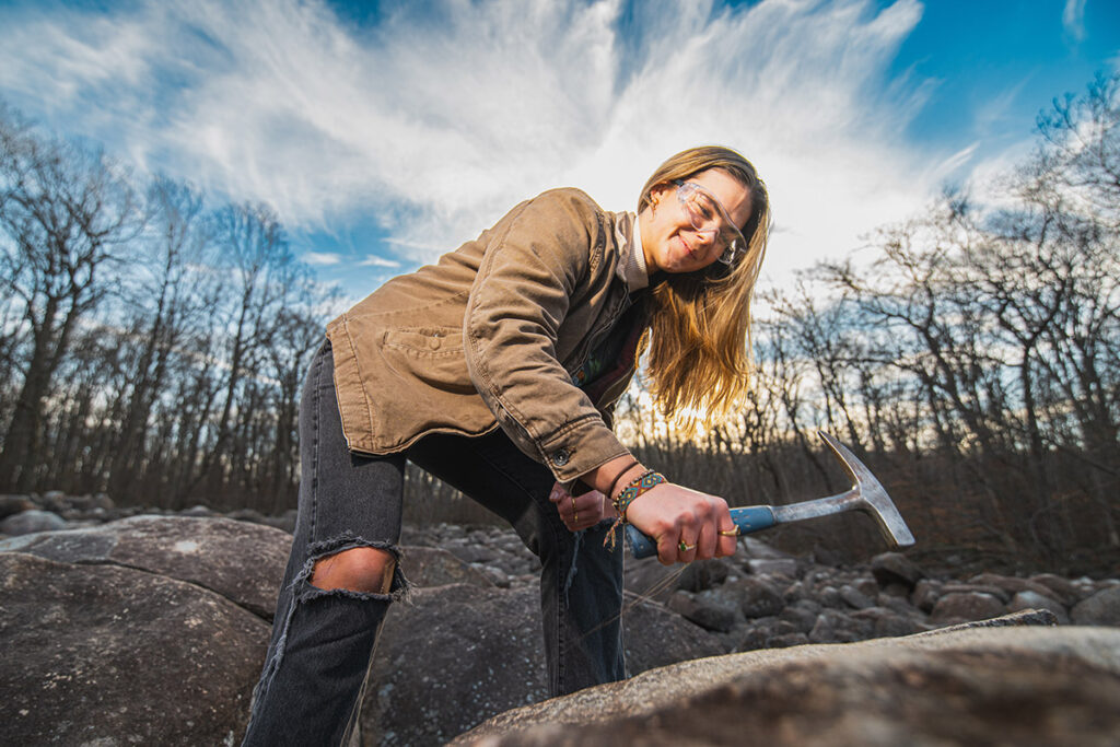 A student with a hammer, getting ready to "ring" a rock.