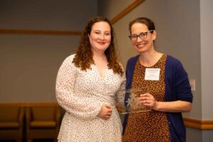 Meredith Forman '24 stands with Prof. Caroline Lee and holds an award at the Landis 2024 awards ceremony.