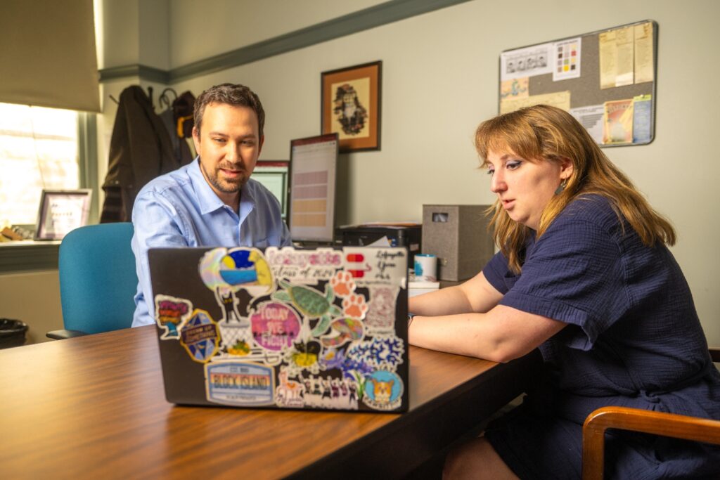 Ainsley Carlson ’24 and Adam Biener, assistant professor of economics, review their work. 