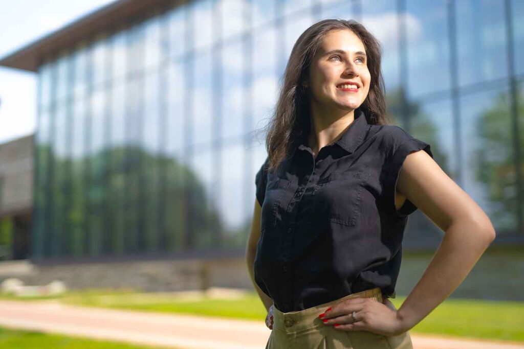 Ami Figuerrutia ’25 is standing on the Quad. Skillman Library is in the background.