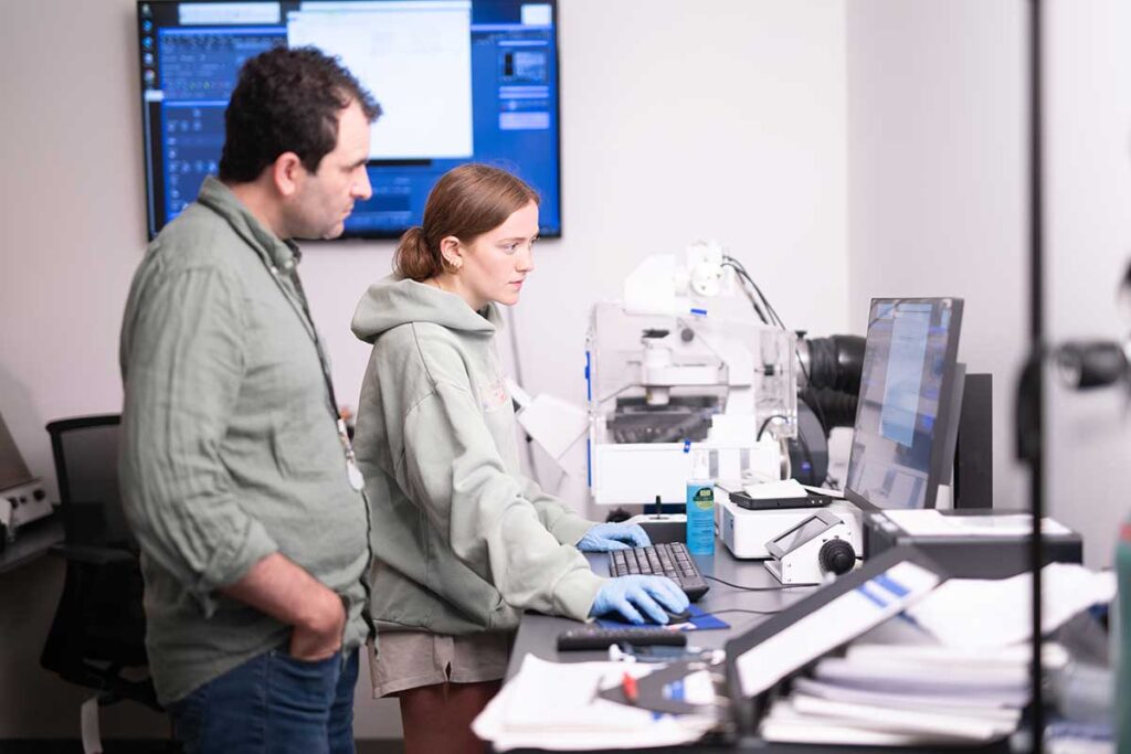 Prof. Ezra Lencer and student Sophia Guitar conducting research in a biology lab