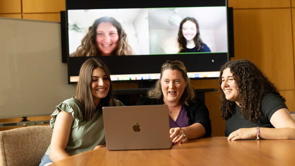 Professor Lauren Myers discussing research project with students Caroline Hugo ’25, Hayley Katz ’25, Samantha Montague ’26, and Gabriela Pedulla ’26 in a conference room