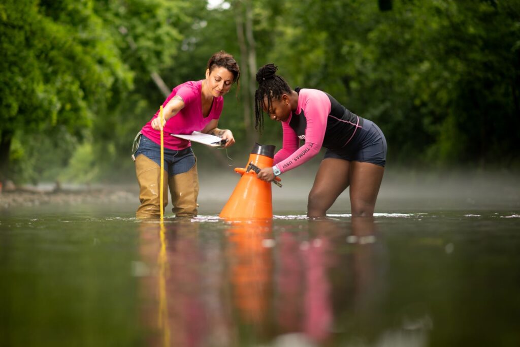 Prof. Meg Rothenberger ’02 and Eurnett Christopher ’25 use a a bathyscope to isolate areas of the creek bed. | Photo by Adam Atkinson