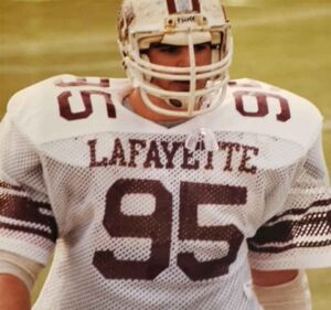 Chris LaPietra '89 is wearing his football uniform and is walking on the field.