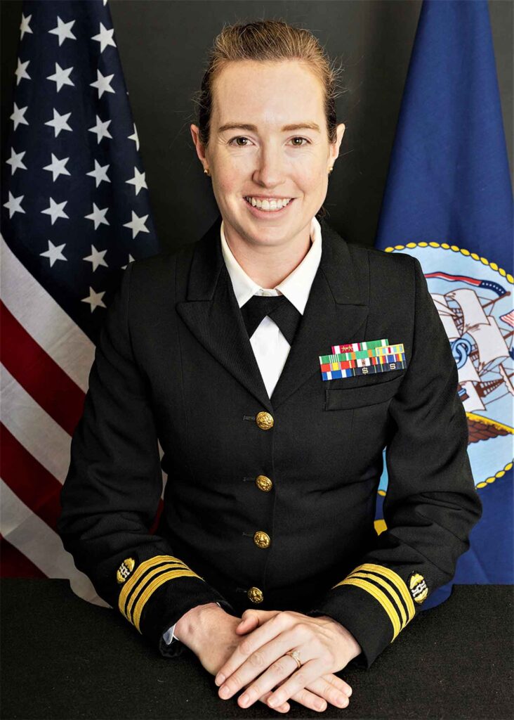 Head shot of Lauren Hugel Snyder '06. Lauren is pictured in a Navy officer's uniform. Her hands are folded and she is smiling at the camera.