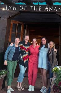 Lauren (second from left) is standing arm in arm with fellow alumnae at the Inn of the Anasazi: left to right: Alix Holstclaw '06, Kristin Rhebergen '06, Colleen Cardella '06, and Kristan Dietz '06. They are smiling at the camera.