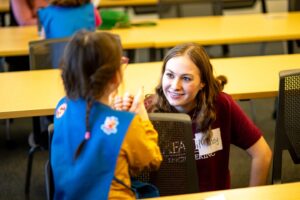 Girl Scout and Lafayette Student work together on a project during the girl Scout Badge Day