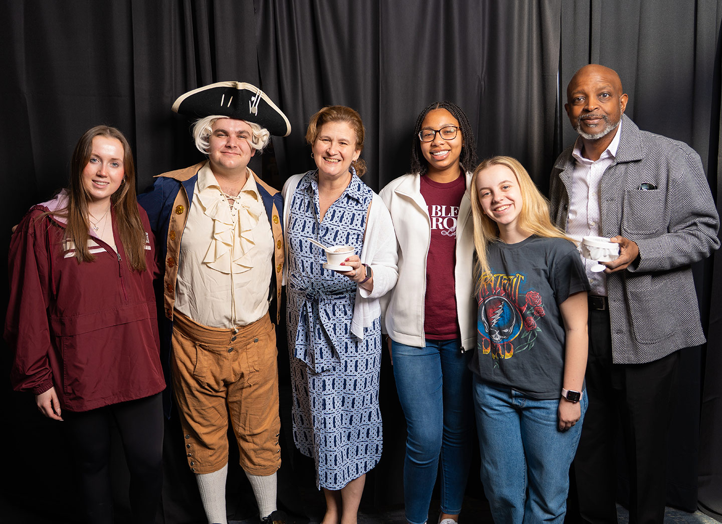 President Nicole Hurd (center) stands with students and staff. She is holding ice cream and one student is dressed as Marquis de Lafayette. 