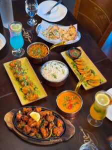 A view from above shows several tandoori dishes, curry, rice and more on the table at Aman's Artisan Indian Cuisine