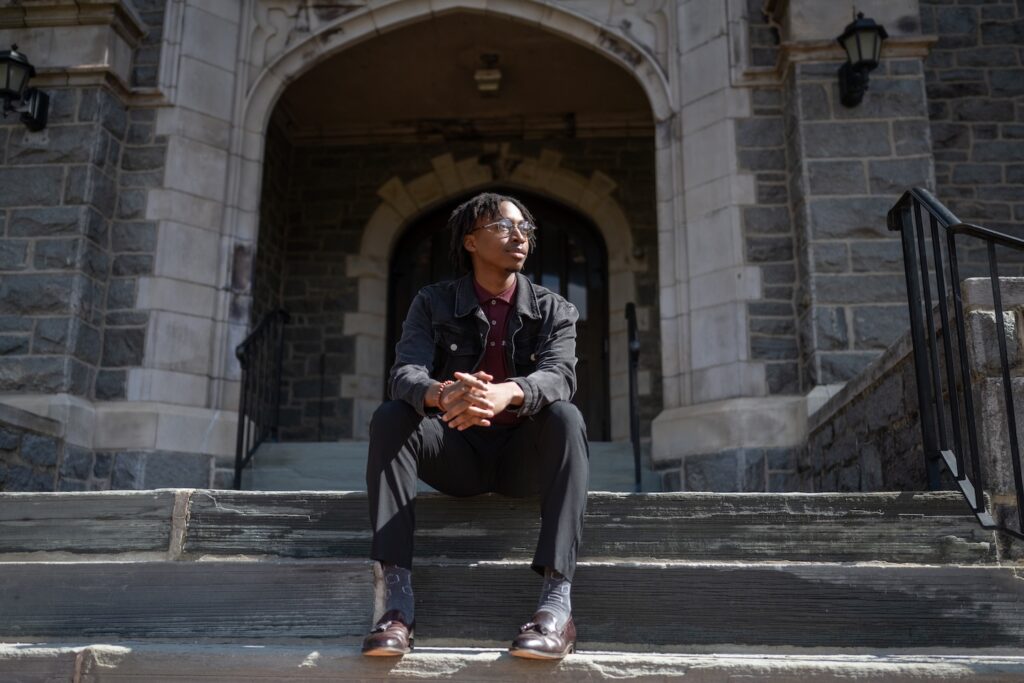 Duly Olivert sits on the steps of Hogg Hall.