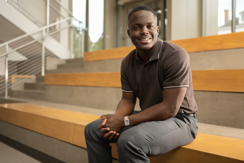 Andrey "AJ" McIntyre sits inside the Simon Center for Economics.