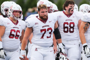 Thomas Grippo '25 stands in his football uniform with his teammates. 