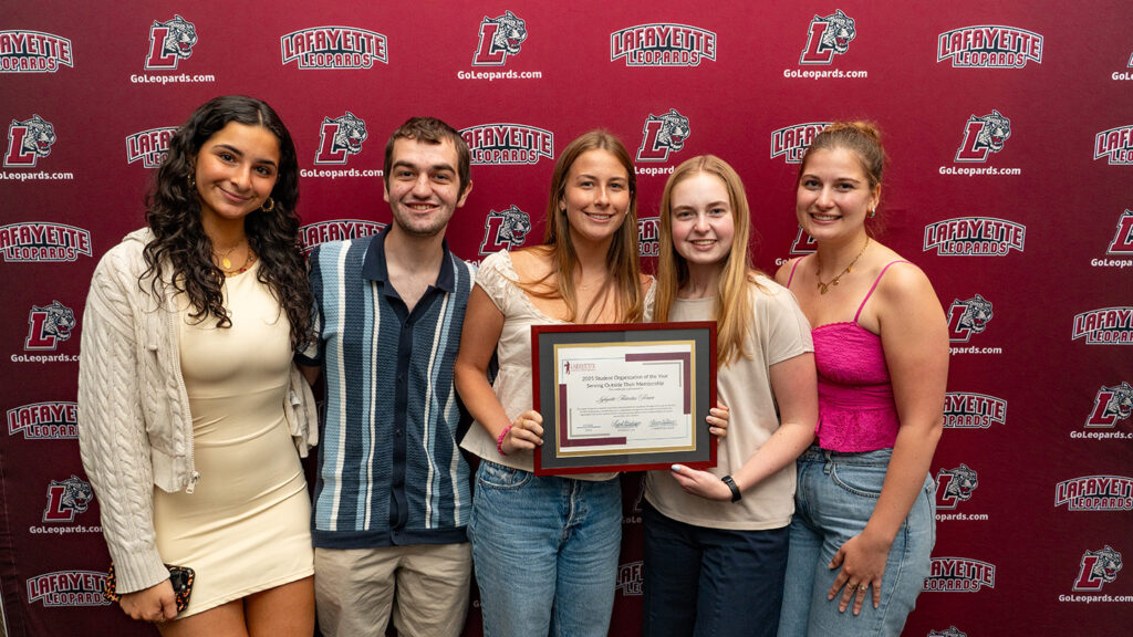 Five members of the Lafayette Activities Forum stand and smile. They are holding a framed award.