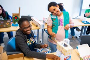 Girl Scout and Lafayette faculty member working on a project together in a classroom during Girl Scout Badge Day