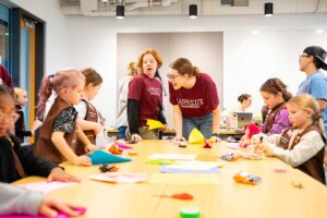 Girl Scouts and Lafayette students working on a project together in a classroom during Girl Scout Badge Day