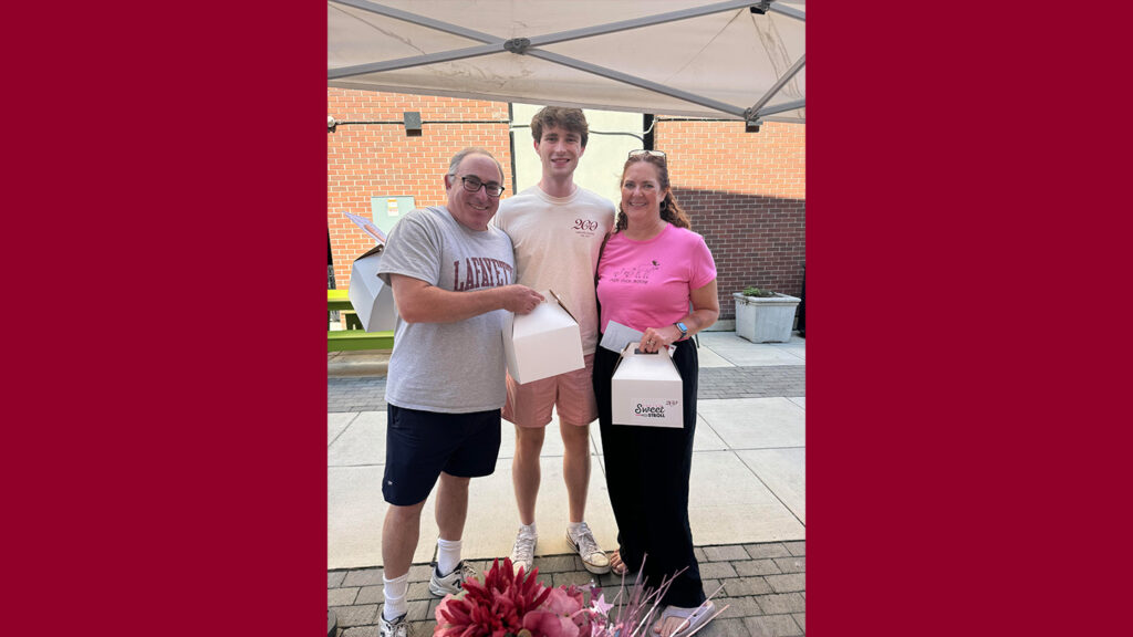 A maroon background with an image of three visitors holding boxes from GEDP's Sweet Stroll in Easton. 