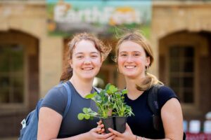 Two students hold a plant
