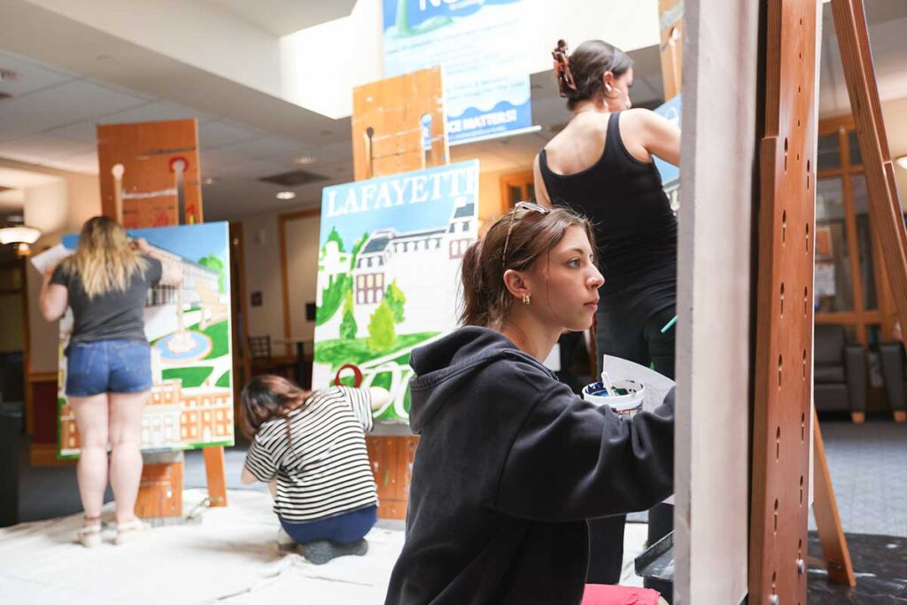 Group of students painting the Founders' Week mural together