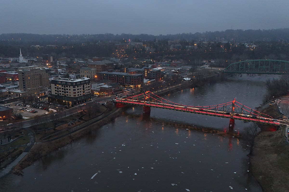 An aerial of the bridge lit up in maroon
