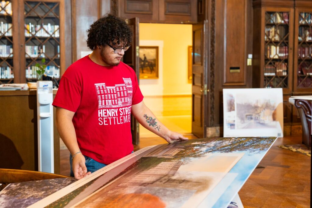 Jesse Kronenfeld Casis ’29 reviews final panels during installation of Adaptations of College Hill: A Bicentennial Exploration Through Rephotography in Kirby Hall of Civil Rights Library. | Photo by JaQuan Alston